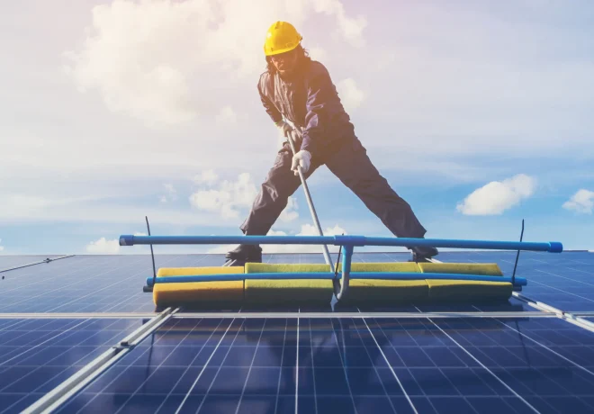 low-angle-view-male-technician-cleaning-solar-panels-against-sky_s low-angle-view-male-technician-cleaning-solar-panels-against-sky_s